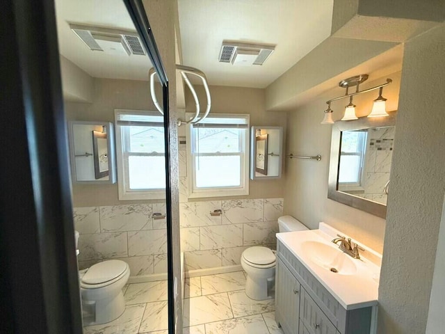 full bath featuring tile walls, toilet, visible vents, and marble finish floor