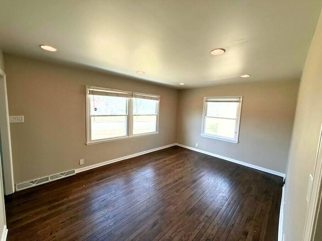 unfurnished room with visible vents, recessed lighting, baseboards, and dark wood-style flooring