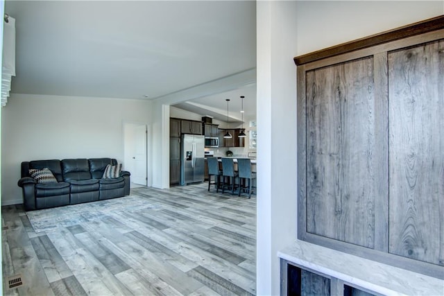 living room featuring lofted ceiling and light wood-style floors