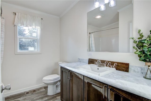 bathroom featuring baseboards, toilet, ornamental molding, wood finished floors, and vanity