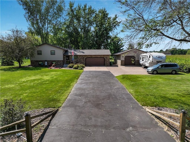 tri-level home featuring an attached garage, concrete driveway, and a front lawn