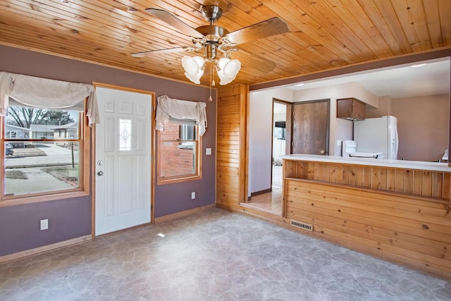 entrance foyer featuring visible vents, baseboards, ceiling fan, wood ceiling, and stone finish floor