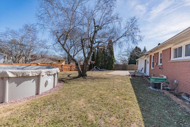 view of yard featuring a patio area, a fenced backyard, a fenced in pool, and central AC