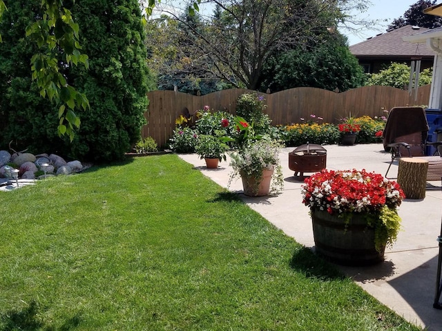 view of yard featuring a patio area, a fire pit, and fence