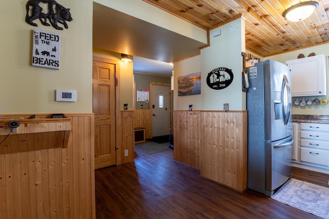 kitchen featuring a wainscoted wall, dark wood finished floors, white cabinets, wood ceiling, and stainless steel refrigerator with ice dispenser