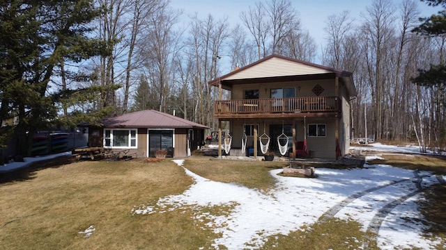 snow covered house featuring a yard and an outdoor structure