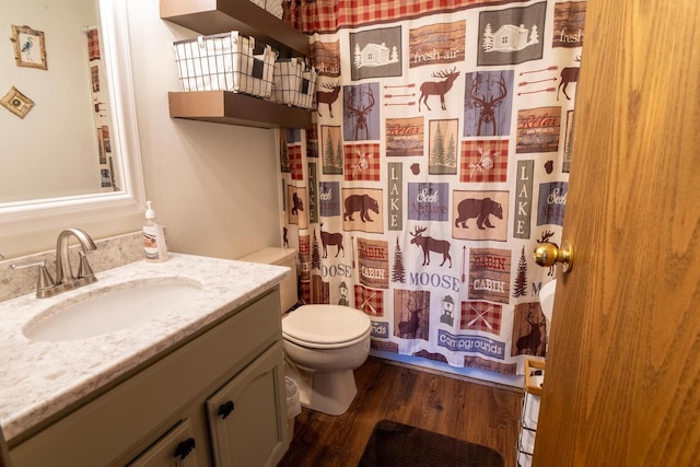 full bathroom with curtained shower, toilet, wood finished floors, and vanity