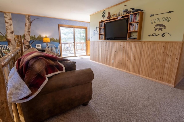 living room featuring carpet flooring, wainscoting, wooden walls, and ornamental molding