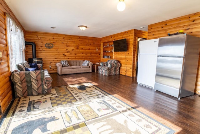 unfurnished living room featuring a wood stove and wood finished floors