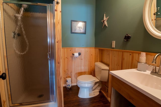 bathroom with wainscoting, vanity, toilet, and a shower stall