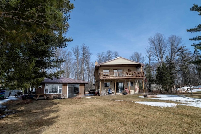 back of property with a chimney, a lawn, and a wooden deck