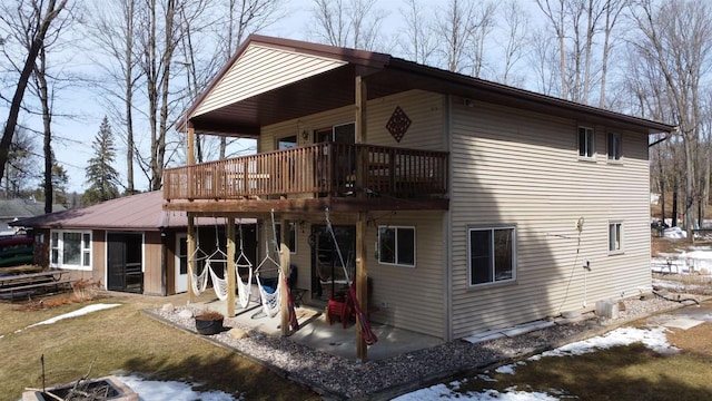 snow covered property with a patio and a wooden deck