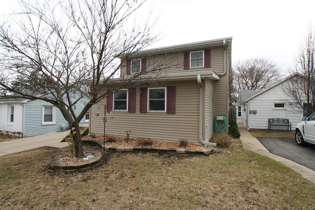 traditional home with aphalt driveway and a front yard