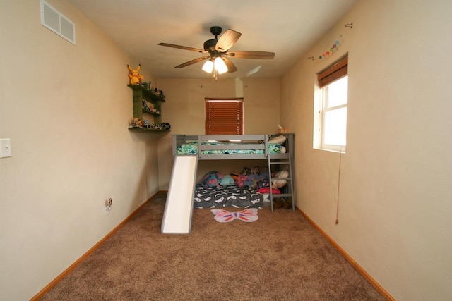 carpeted bedroom with a ceiling fan, baseboards, and visible vents