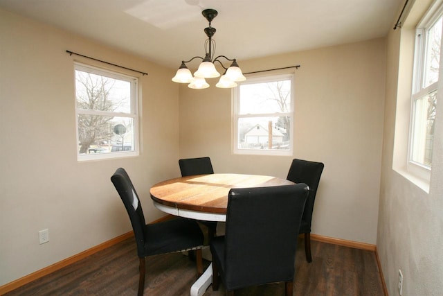 dining area with an inviting chandelier, plenty of natural light, and wood finished floors