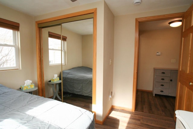 bedroom featuring a closet, baseboards, and wood finished floors