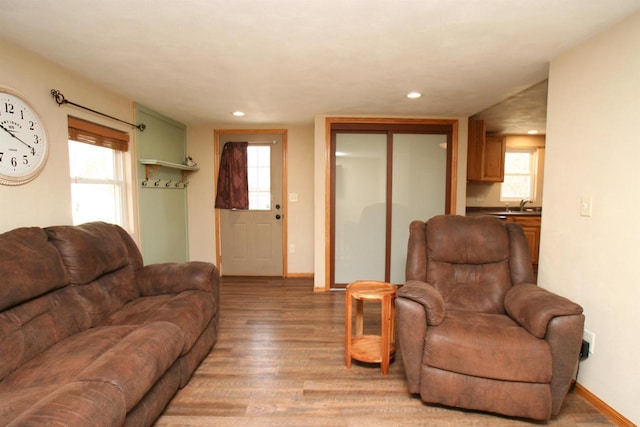 living area featuring recessed lighting, a healthy amount of sunlight, baseboards, and light wood-style floors