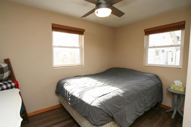 bedroom featuring multiple windows, ceiling fan, baseboards, and wood finished floors