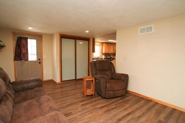 living area featuring recessed lighting, dark wood-style floors, visible vents, and baseboards