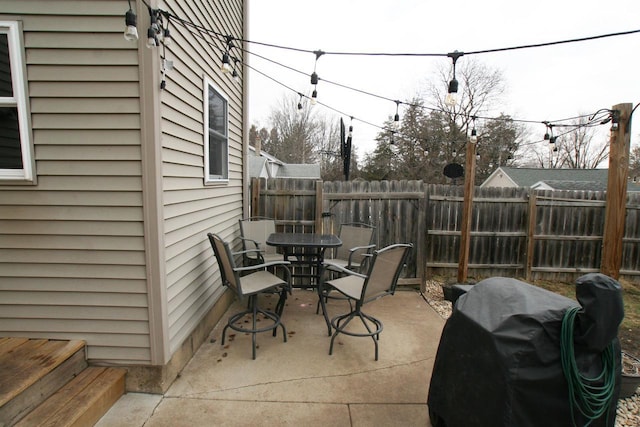 view of patio with area for grilling, outdoor dining area, and a fenced backyard