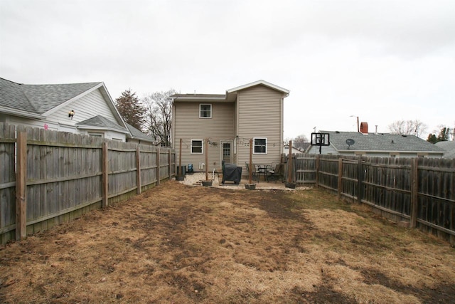 back of property with a patio, a fenced backyard, and central AC