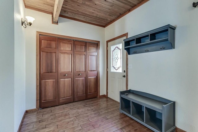 foyer featuring baseboards, light wood-style floors, and wooden ceiling