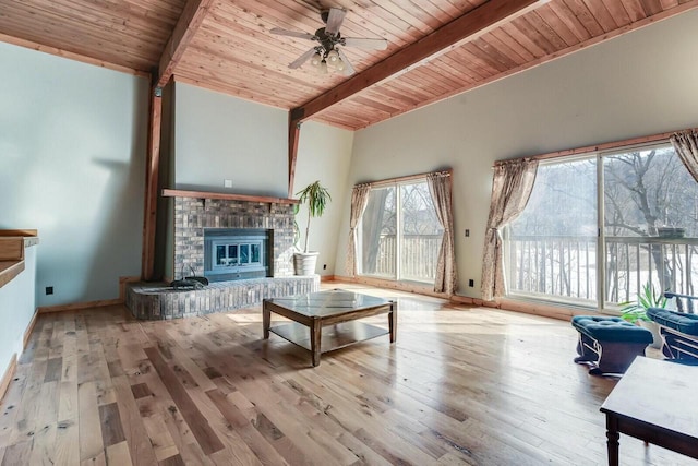 living room featuring a ceiling fan, beam ceiling, a fireplace, hardwood / wood-style flooring, and wooden ceiling