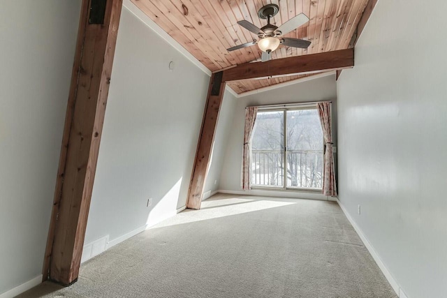 carpeted empty room featuring ceiling fan, wooden ceiling, lofted ceiling with beams, and baseboards