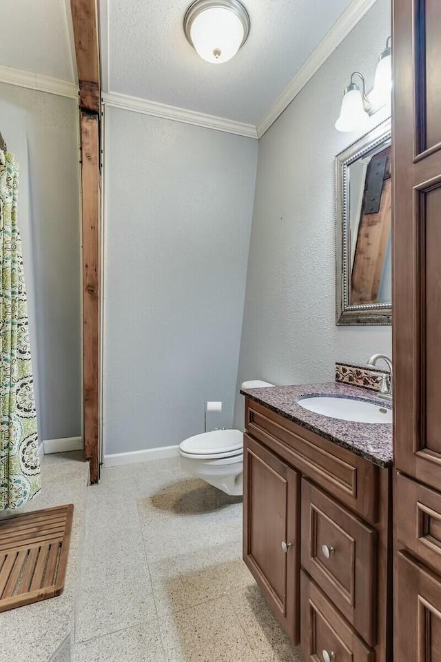 bathroom featuring toilet, vanity, baseboards, and ornamental molding