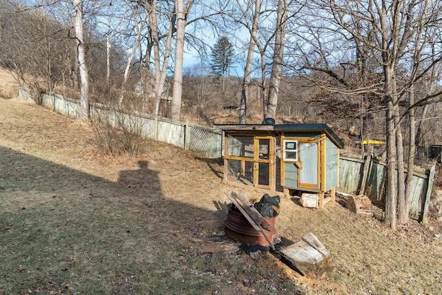 view of yard featuring an outdoor structure, fence, and exterior structure