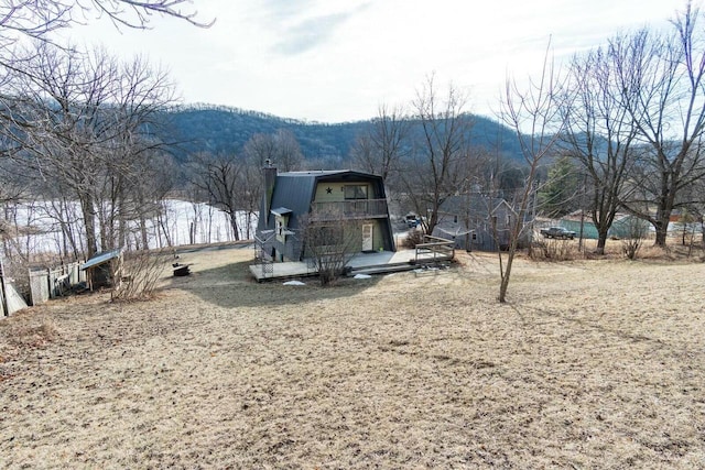 exterior space featuring a gambrel roof and a deck with mountain view