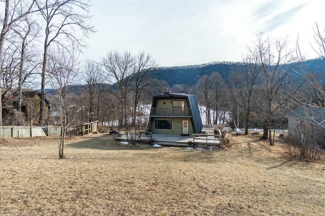 back of house featuring a gambrel roof, a deck with mountain view, and a balcony