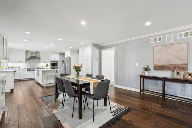 dining space featuring visible vents, dark wood-style flooring, and ornamental molding