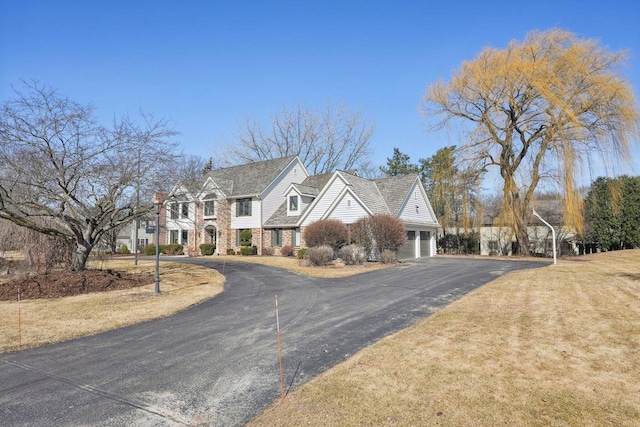 view of front of home featuring aphalt driveway, a garage, and a front yard