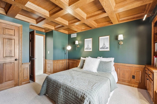 bedroom featuring light carpet, beam ceiling, wainscoting, wooden ceiling, and coffered ceiling