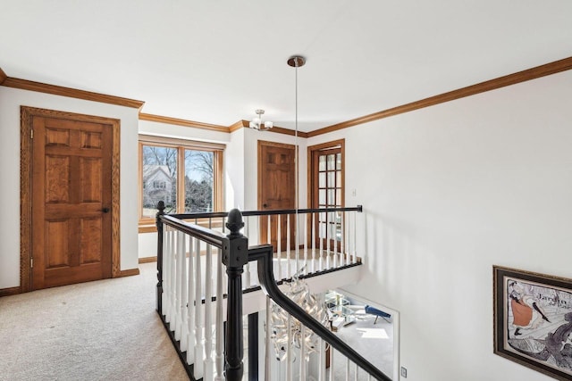 corridor with an upstairs landing, light colored carpet, baseboards, and ornamental molding