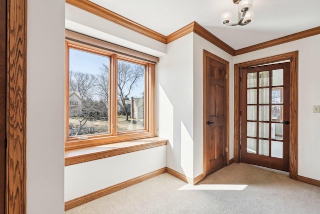 doorway to outside with baseboards, carpet floors, and crown molding