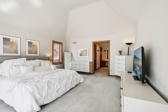 bedroom with light carpet, visible vents, connected bathroom, and high vaulted ceiling