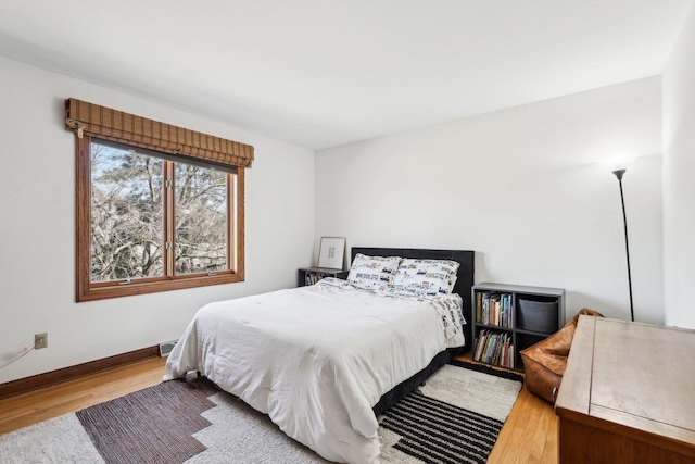 bedroom featuring visible vents, baseboards, and wood finished floors