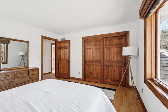 bedroom with visible vents, baseboards, and wood finished floors