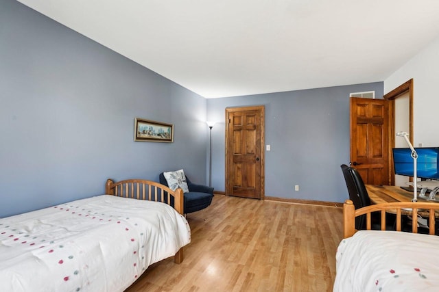 bedroom with light wood-type flooring and baseboards