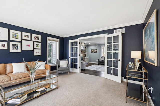 carpeted living area featuring visible vents, french doors, crown molding, and baseboards