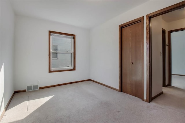 unfurnished bedroom with baseboards, visible vents, and light carpet