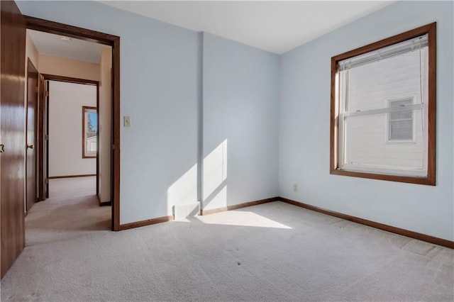 carpeted spare room featuring baseboards