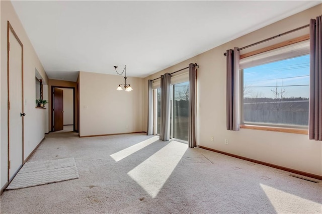 unfurnished room with light carpet, baseboards, visible vents, and a chandelier