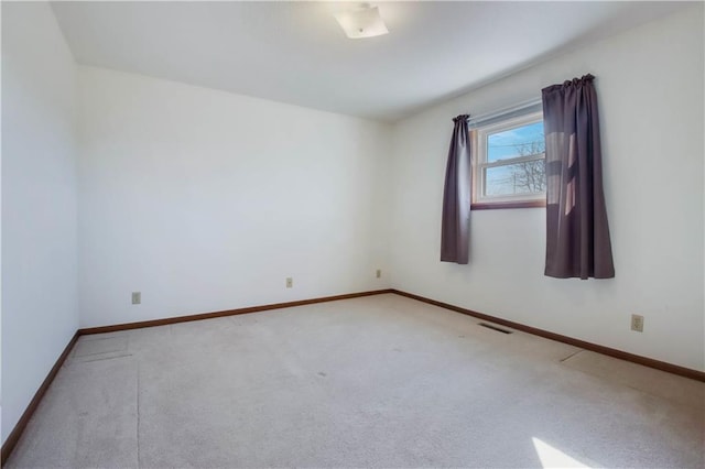 carpeted empty room with visible vents and baseboards