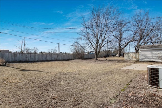 view of yard featuring central air condition unit, an outdoor structure, a shed, and fence