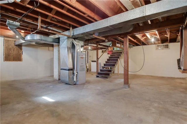 unfinished basement featuring stairs, washer / clothes dryer, and heating unit