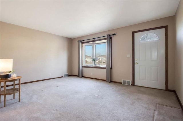 entryway with light carpet, visible vents, and baseboards