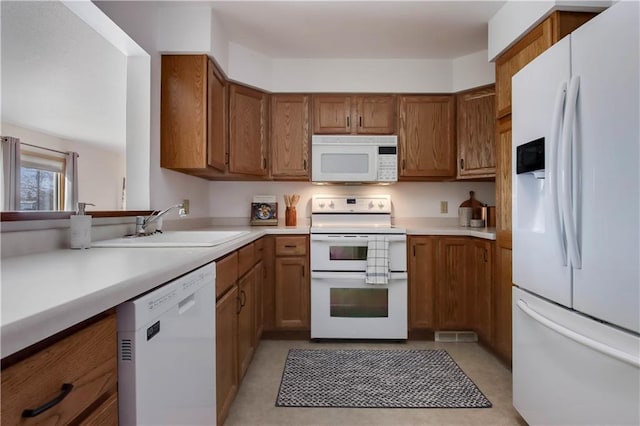 kitchen with white appliances, brown cabinets, and light countertops